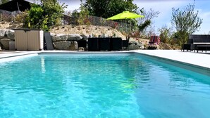 A clear blue pool with a stone wall and a covered seating area. - Gîte & Bed and Breakfast capacity 14 people with swimming pool, labeled 4 keys. (MAUVAISIN)