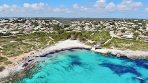 Ein Luftbild einer Küstenstadt mit Strand, klarem, blauem Wasser und Wohngebäuden.