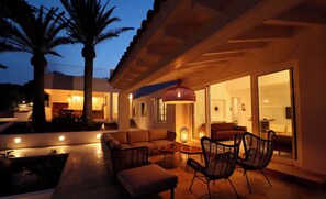 An outdoor living area with a sofa, chairs, and a table.