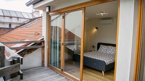 Un dormitorio con una cama, una mesita de noche y un ventanal.