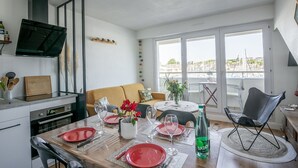 A dining area with a table set for four, a sofa, and a chair.