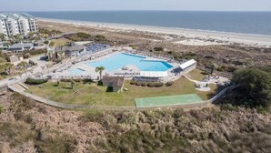 Um resort com uma piscina grande, acesso à praia e vista para o oceano.