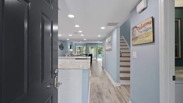 A modern kitchen with a marble countertop and a view of the living area.