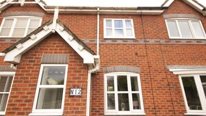 A two-story brick building with white-framed windows and a gable roof. - Fantastic 2-bed House in Hull. Garden, Sky tv (Hull)