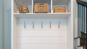 Un banc blanc avec un dessus en bois et un mur blanc orné de panneaux horizontaux.