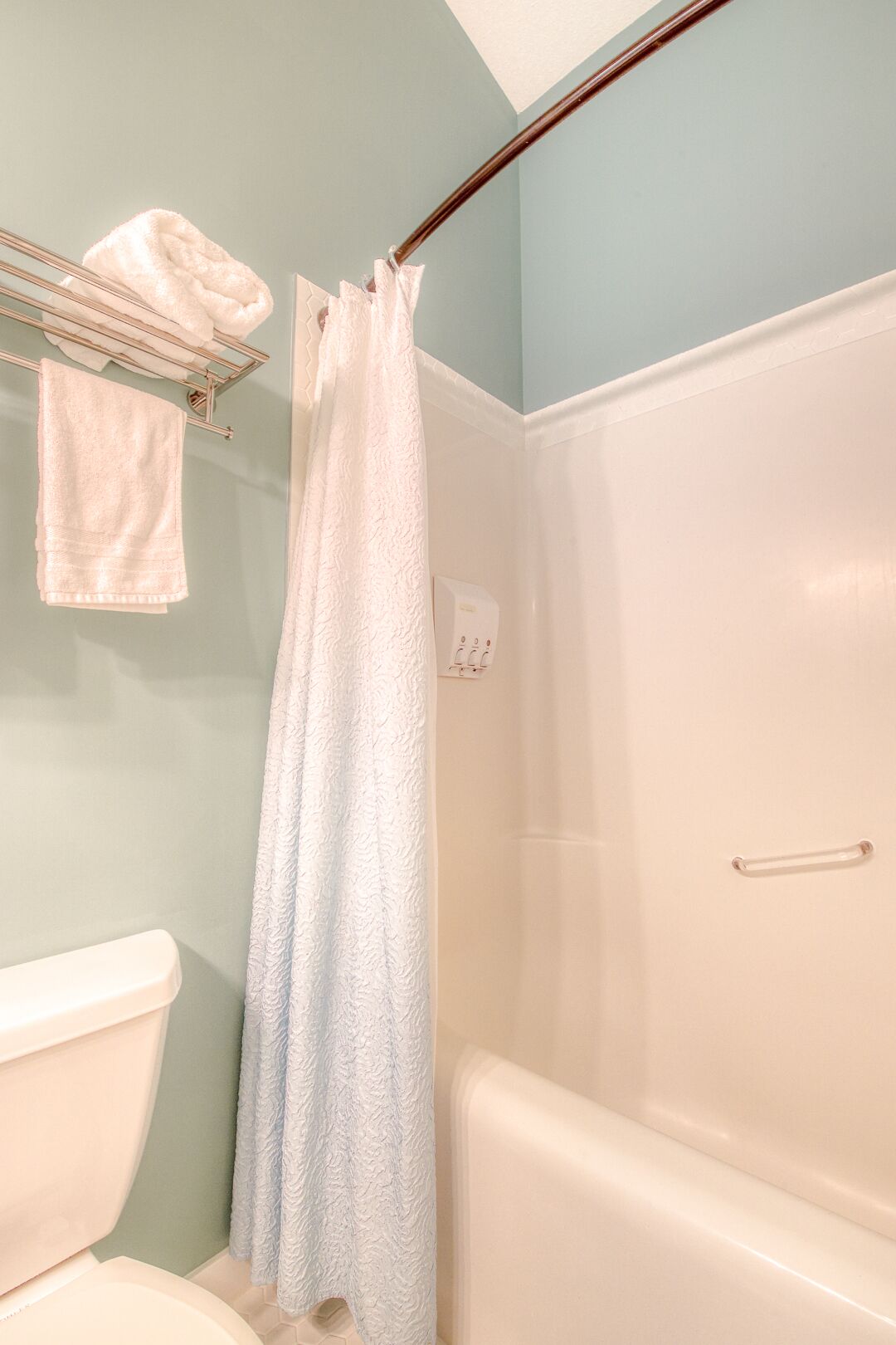 Un baño con inodoro, bañera y cortina de ducha.
