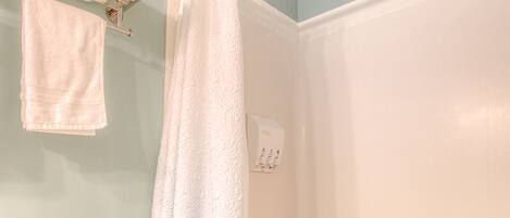 Un baño con inodoro, bañera y cortina de ducha.