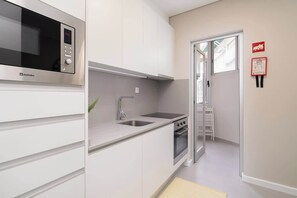Une cuisine moderne équipée d’un four à micro-ondes, d’un évier et d’une cuisinière.