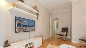 Ein modernes Wohnzimmer mit Flachbildfernseher, weißem Unterhaltungsschrank und rundem Couchtisch.