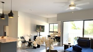 A modern living room with a dining area, a large window, and a ceiling fan. - Luxury & safety. PALCCO, Akron, ITESM, ValleReal (ZAPOPAN)