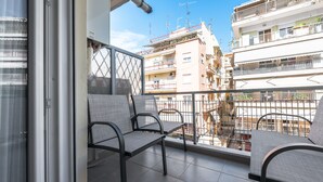 Ein Balkon mit zwei Stühlen und einer Glastür.