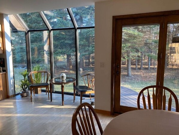 Enjoy a serene forest view from the comfort of this room, featuring an outdoor area and stylish seating.