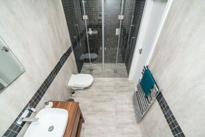Enjoy a refreshing shower in this sleek bathroom with a shower enclosure, toilet, and vanity.