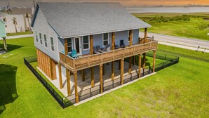 Une maison à deux étages dotée d’un balcon, d’un porche abrité et offrant une vue sur l’eau.