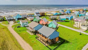 Un quartier résidentiel situé sur la côte, avec des maisons aux couleurs vives, une plage et une vue sur l’océan.