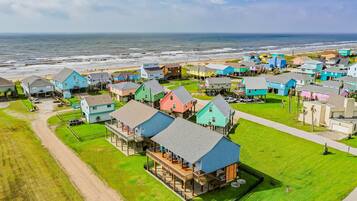 A coastal residential area with colorful houses, a beach, and a view of the ocean.