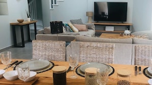 A modern living room with a dining area set for a meal.