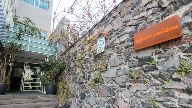 A stone wall with a sign for 'Hostal Ramundos' and a no-smoking sign. - El Gran Hostal (Guadalajara)
