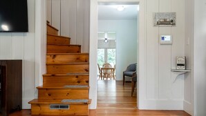 Eine Holztreppe führt zu einem Essbereich mit Tisch und Stühlen.