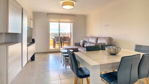 A modern apartment with a dining area, a sofa, and a balcony with a view. - 3071 Vista Azul XXIX 3071 (Orihuela Costa)