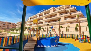 A children's play area with a slide and climbing structure, a multi-story building in the background, and a sign reading 'VISTA PARK'. - 3071 Vista Azul XXIX 3071 (Orihuela Costa)