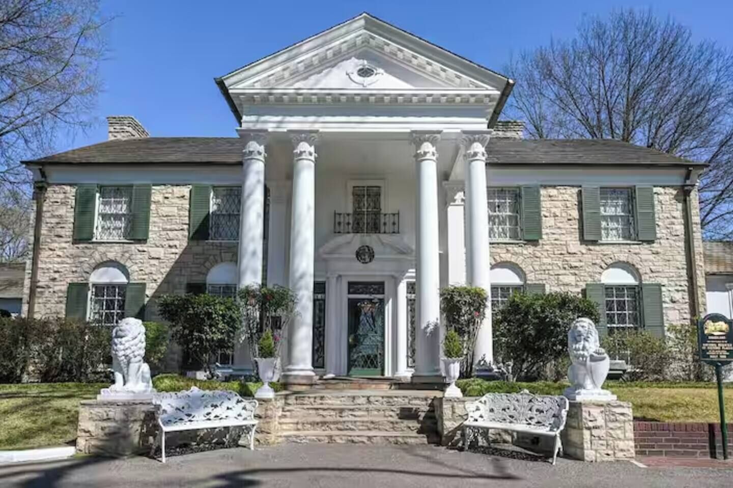 Un edificio de piedra grande con una entrada central flanqueada por columnas, una fachada simétrica y estatuas a ambos lados.