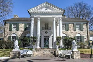 A large stone building with a central entrance flanked by columns, a symmetrical facade, and statues on either side. - Downtown Gem | Near Beale, Bars n Blues (Memphis)