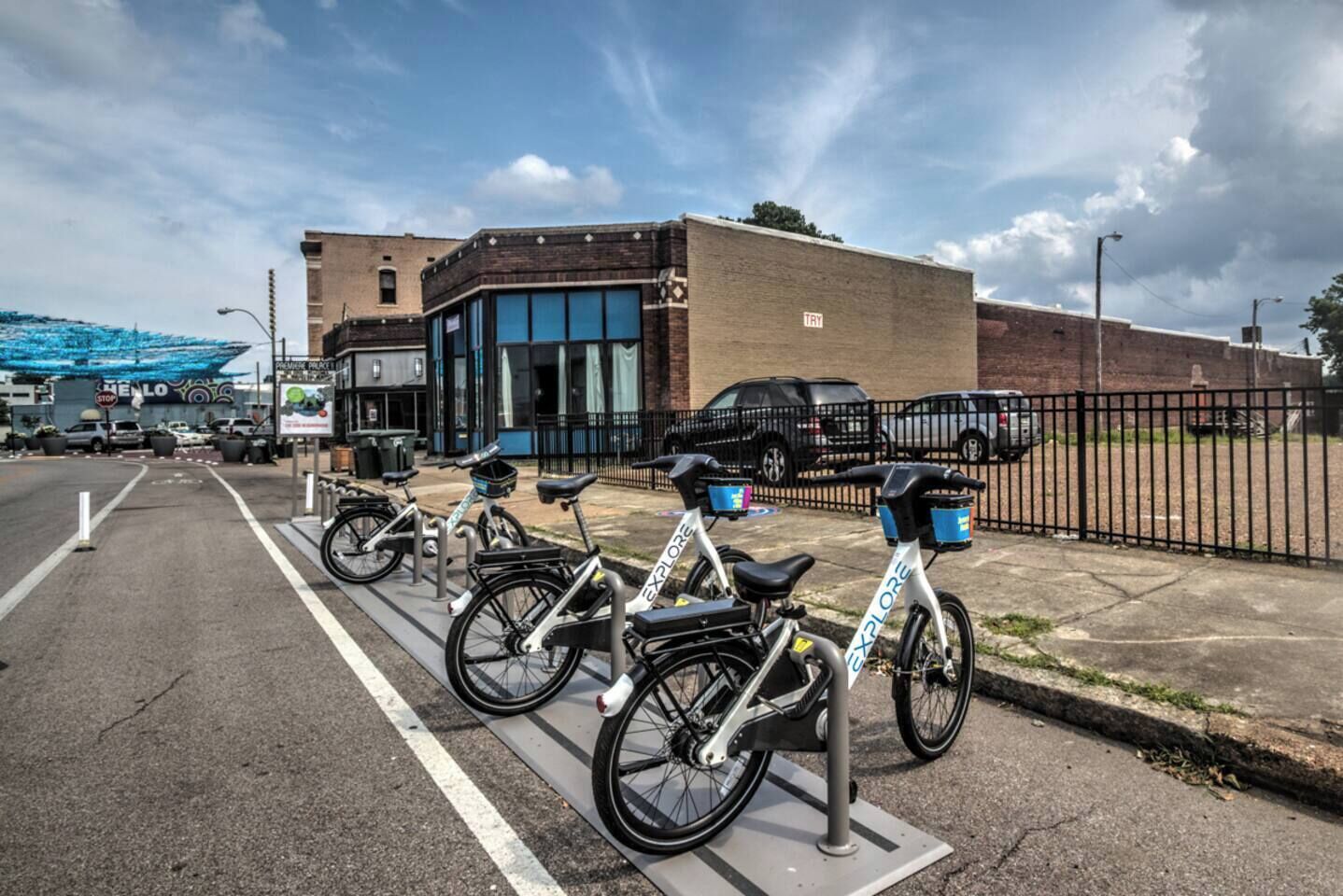 A parking area with bicycles and a building in the background.