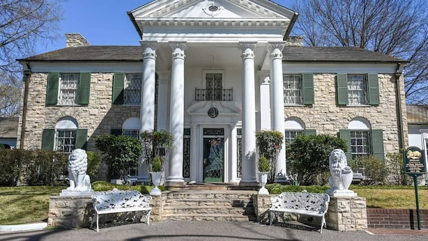 A large stone building with a central entrance flanked by columns, two statues, and a green door. - Prime Downtown Hub | Walk to Beale, Culture & Eats (Memphis)