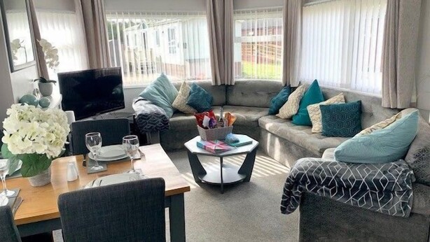Un salon moderne comprenant un canapé, une table basse, un téléviseur et un coin repas avec une table et des chaises.