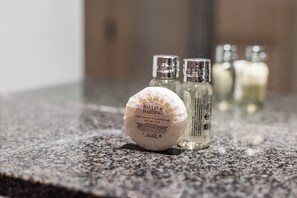 A Baylis & Harding soap bar and two bottles on a granite countertop. - The Aldgate Apartments (London)