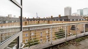 A view from a window overlooking a row of terraced houses with a metal railing in the foreground. - The Aldgate Apartments (London)