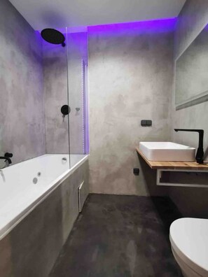 A modern bathroom with a bathtub, a toilet, and a sink. - Big 4-bedroom flat, terrace with great Vítkov view (Prague)