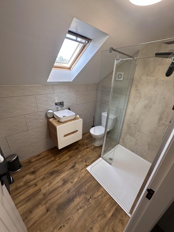 A modern bathroom with a skylight, a shower, and a wooden floor. - King Size bed - Free Parking - 5 min to Centre (Lincoln)