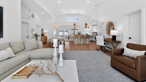 A spacious living area with a sofa, coffee table, and a dining area with chairs and a table. - Luxury Dewey Beach Home, Private Beach Block, 4 Bed, 2.5 Bath, Park 3 Cars (Rehoboth Beach)