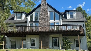 A two-story house with a stone chimney, multiple windows, and a balcony. - Cardinal's Nest - Secluded 9+ Acres, 3,000+ sq. ft., firepit in Columbia, TN (Columbia)