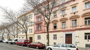 Eine Reihe mehrstöckiger Gebäude mit parkenden Autos an einer Straße.