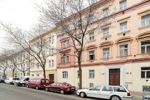 A row of multi-story buildings with parked cars along the street. - Central designer studio by beautiful park & church (Prague)