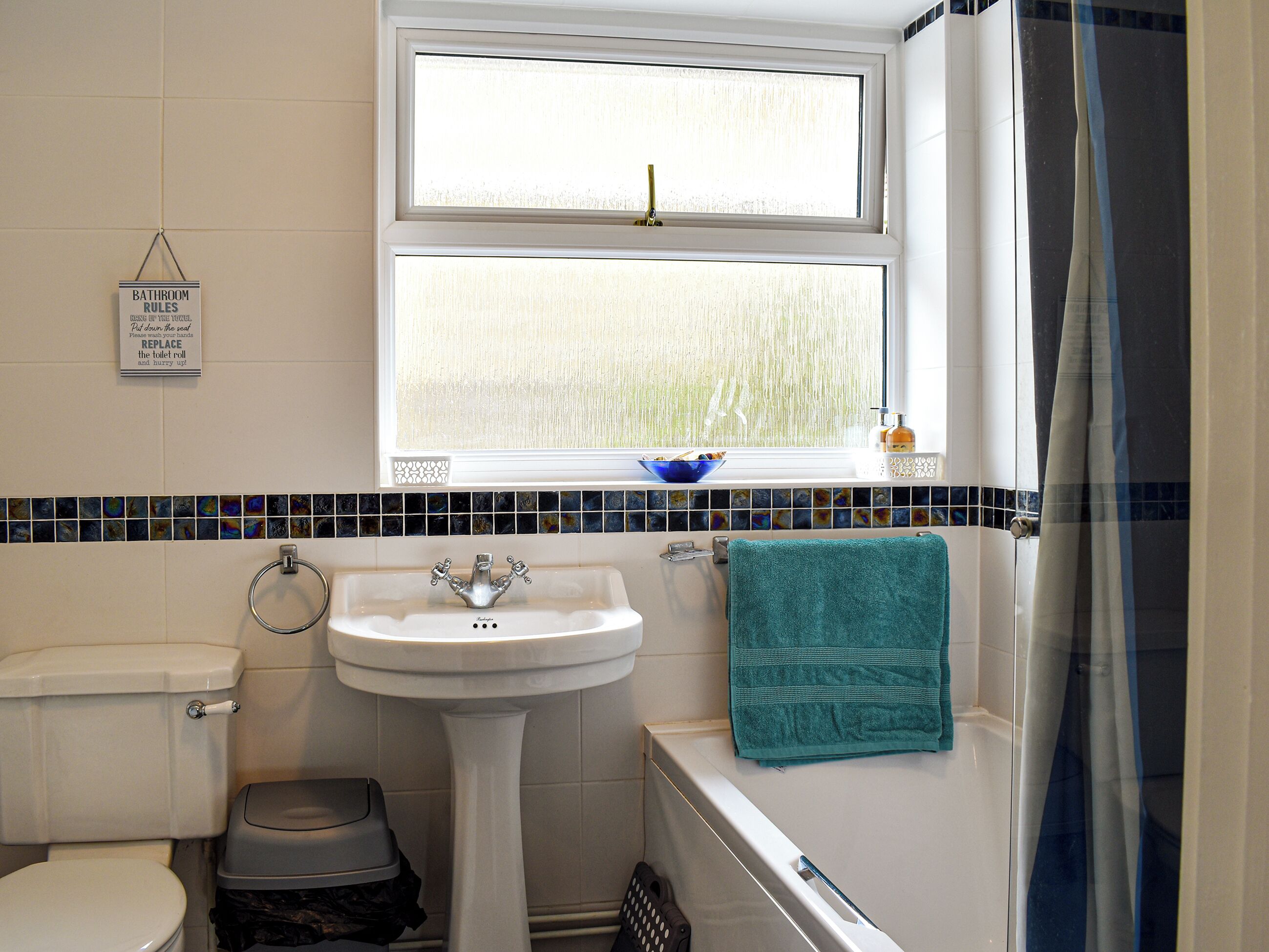 Un baño con inodoro, lavamanos y bañera.