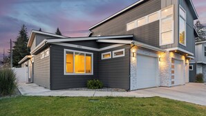 A modern two-story house with a garage, a well-maintained lawn, and a clear sky. - New Modern Townhome- downtown CDA-minutes to waterfront, restaurants, and shops! (Coeur d'Alene)