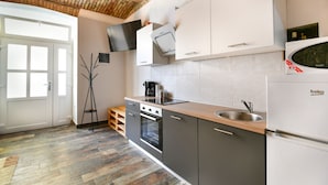 A modern kitchen with a built-in oven, a sink, and a refrigerator.