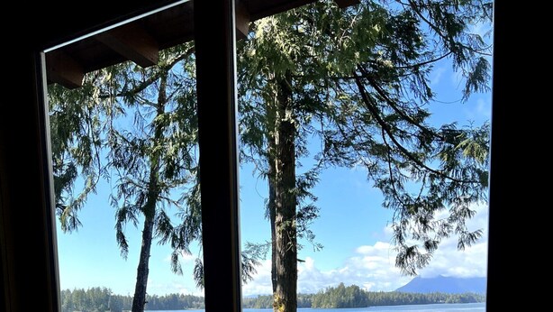 A wooden deck with a view of a lake and trees. - Coastal View-Rated top place to stay on the inlet! (Tofino)