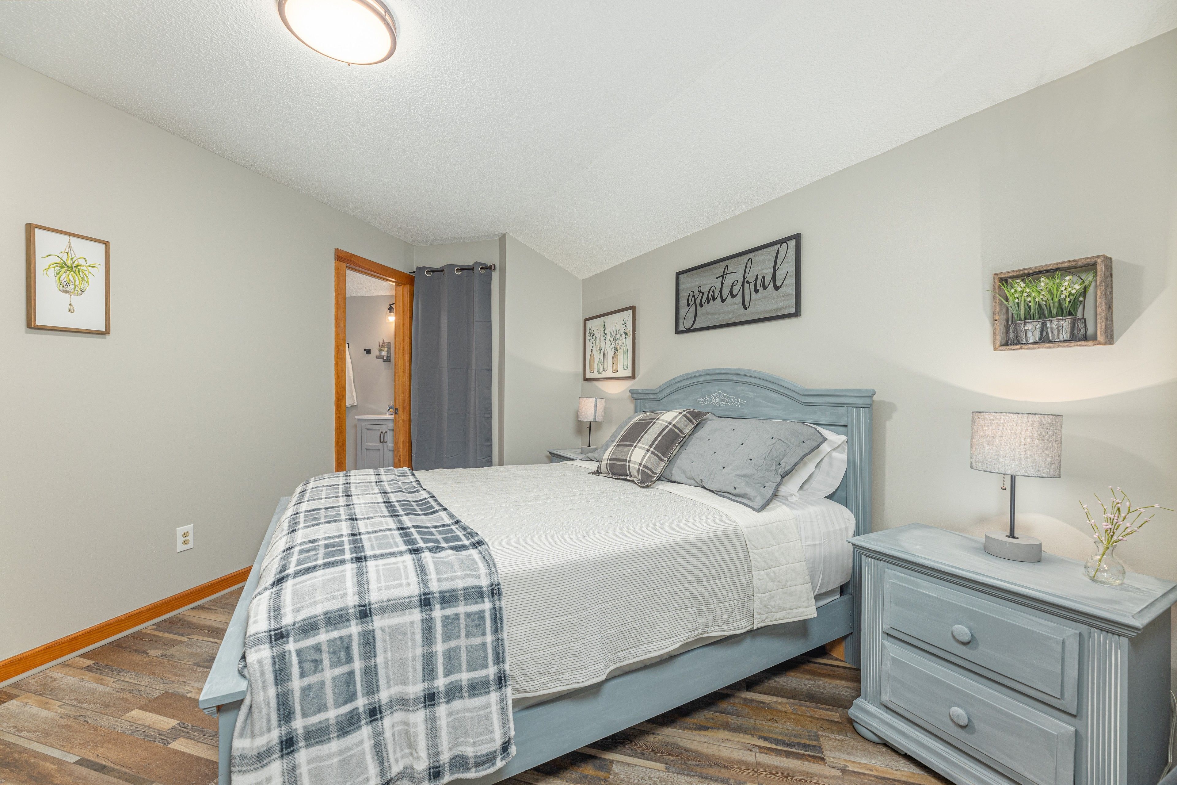 A bedroom with a bed, bedside table, and a nightstand.