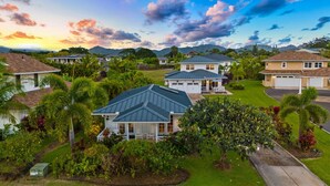 A residential area with houses, lush greenery, and a clear sky. - *NEW Poipu 2BR Retreat|Pool|AC & Athletic Club (Koloa)