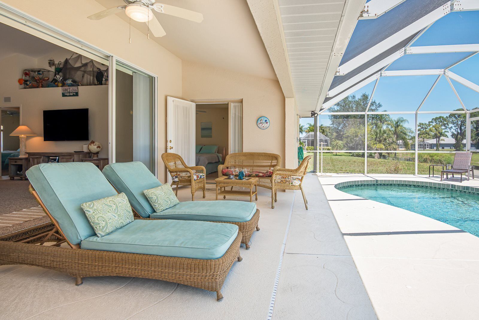 Un espace aménagé au bord de la piscine, avec des fauteuils de relaxation en osier et une piscine.