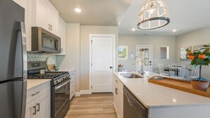 A modern kitchen with stainless steel appliances, a wooden countertop, and a central island. - BLACK SHEEP INN Newly Constructed Suffolk #2 of 4 Units  (Cedar City)