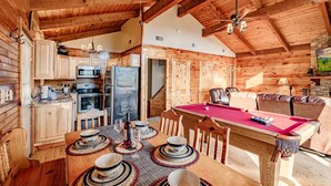 A wooden cabin interior with a dining area, kitchen, and pool table. - 🏔Sunset Mtn views!⛰ 5 min to PFORGE🚙  HOT TUB! ♨️ (Pigeon Forge)