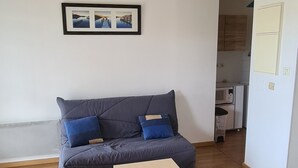 Ein Wohnzimmer mit grauem Sofa, einem Holztisch und einer Deckenleuchte.