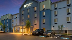 A MainStay Suites building with a modern design, featuring a covered entrance and a parking area with marked handicapped spaces.