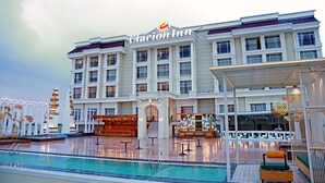 Un hotel Clarion Inn con piscina, asientos exteriores y una entrada bien iluminada.